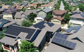 aerial view of solar panels installed on rooftops