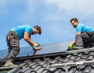 Solar installer on roof installing solar panels 