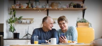 Couple in kitchen looking at phone