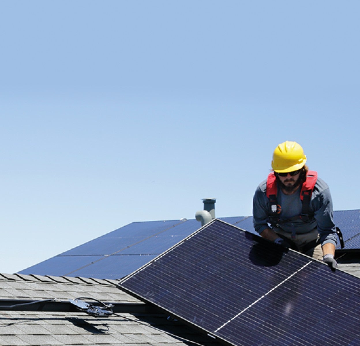 Installer installing solar panels at roof